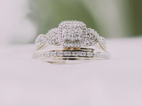 A cushion halo engagement ring stacked with a pave band on a white cushion