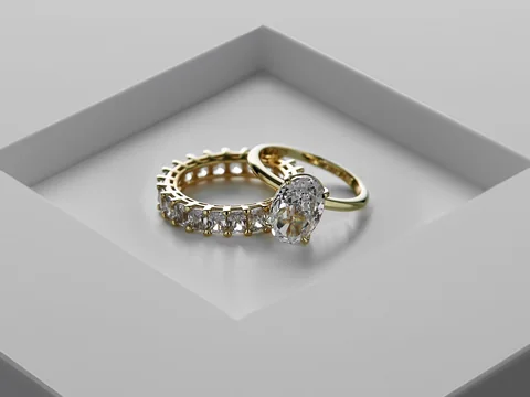 A diamond engagement ring and a diamond eternity band set in a square recess of a pale gray surface